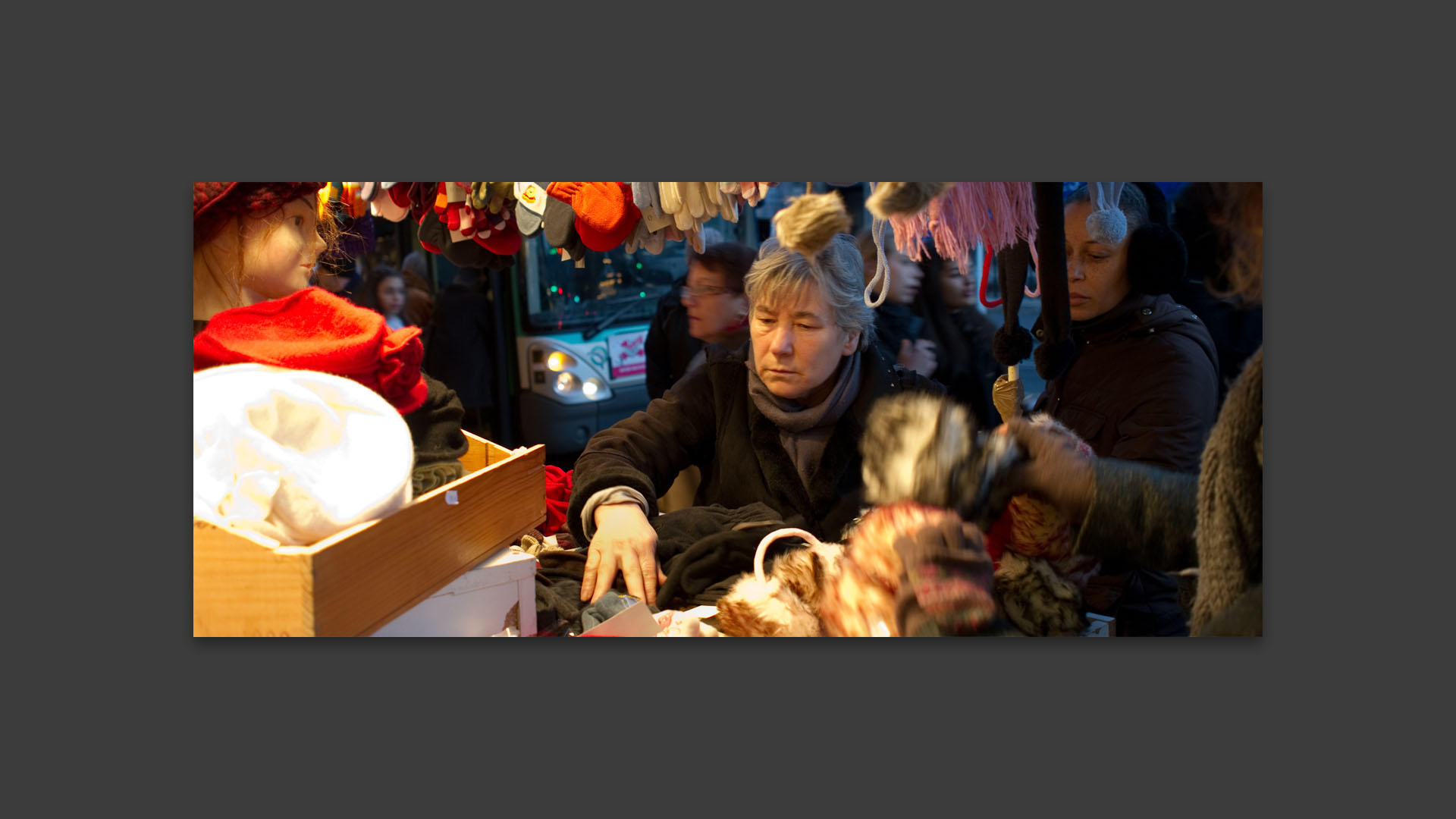 Femme fouillant dans un étal devant le Bazar de l'Hôtel de Ville, rue de Rivoli, à Paris.